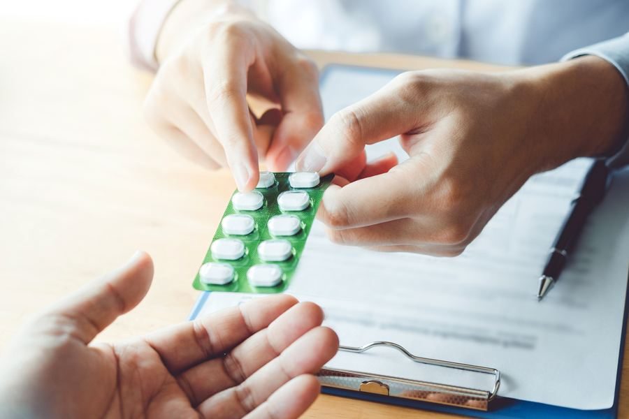 A blister strip of tablets beside a clipboard