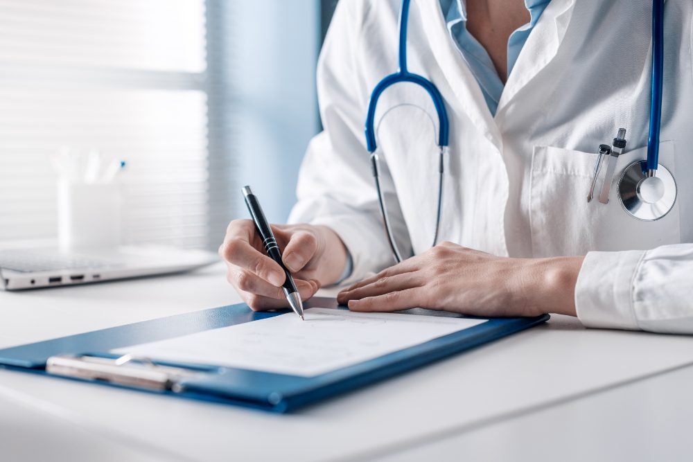 A doctor writing a prescription at a desk